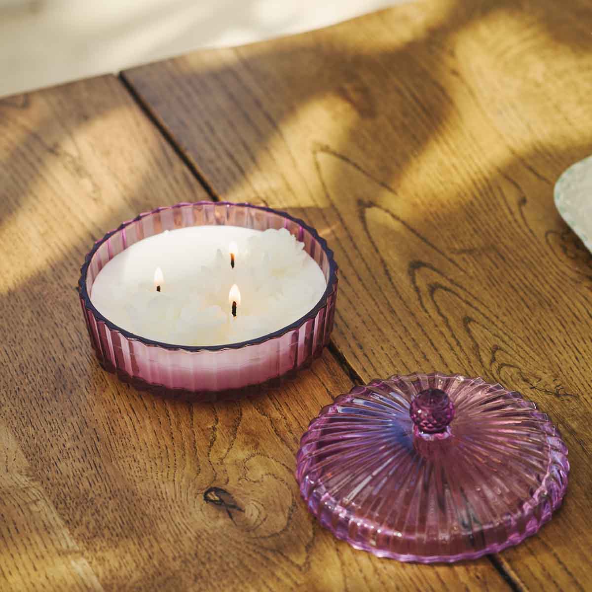 Garden Beauty Specialty Jar - Wildflower Walk shown lit with the lid off on a wooden table top.